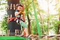 Kid climbing in high rope course in adventure park. Boy in safety helmet, extreme sport. Summer camp for kids Royalty Free Stock Photo