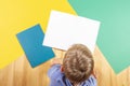 Kid with colorful books notebooks reading and doing homework