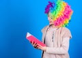 Kid colorful curly wig artificial hair clown style hold book. Reading jokes. Time to have fun. Circus school. Study hard