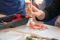 Kid coloring a wooden sheet