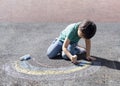 Kid colouring rainbow on pavement, Child drawing rainbow with colourful chalks on footpath during Covid-19 quarantine at home,Home