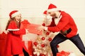 Kid cute girl play with father near christmas tree. Playful daughter and dad celebrate christmas. Winter activity and