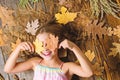 Kid cute girl play with leaves wooden background top view. Child long hair play with dry leaves. Autumn coziness is just