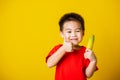 Kid cute little boy attractive smile playing holds bananas and show finger thumb for good sign Royalty Free Stock Photo