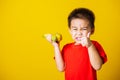 Kid cute little boy attractive smile playing holds bananas and show finger thumb for good sign Royalty Free Stock Photo