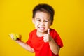 Kid cute little boy attractive smile playing holds bananas and show finger thumb for good sign Royalty Free Stock Photo