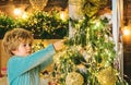 Kid decorating Christmas tree with bauble. Christmas decorations. Portrait of Santa kid with bauble looking at camera Royalty Free Stock Photo