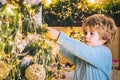 Kid decorating Christmas tree with bauble. Portrait of Santa kid boy with bauble. Happy kids new year. Royalty Free Stock Photo