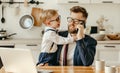 Kid distracting busy father from work at home