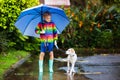 Kids in puddle in autumn rain. Waterproof wear Royalty Free Stock Photo