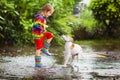 Kids in puddle in autumn rain. Waterproof wear Royalty Free Stock Photo