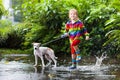 Kids in puddle in autumn rain. Waterproof wear Royalty Free Stock Photo