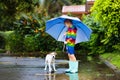 Kids in puddle in autumn rain. Waterproof wear Royalty Free Stock Photo