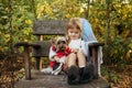 Kid with dog are sitting in big wooden chair