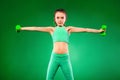 Kid girl doing fitness exercises on green background