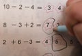 Kid doing homework of simple subtraction & addition Royalty Free Stock Photo