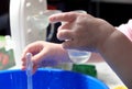 Kid doing scientific experiment at home with liquids holding a test tube and a pasteur pipette. Hands close-up, the concept of