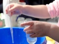 Kid doing scientific experiment at home with liquids holding a test tube and a pasteur pipette. Hands close-up, the concept of