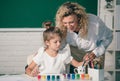 Kid drawing with teacher. Children from elementary school study at draw lesson. Pupil with teacher painting. Teacher and Royalty Free Stock Photo