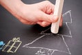 Kid drawing winter Christmas scene with a white chalk on the blackboard Royalty Free Stock Photo