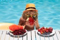 Kid drink cocktail, strawberry smoothie in the pool. Child in swimming pool with summer fruits. Kids summer vacation Royalty Free Stock Photo