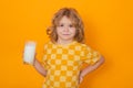 Kid drink fresh milk. Cute kid drinking milk on yellow background.