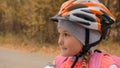 Kid drink water from an aluminum flask. One caucasian children rides bike road in autumn park. Little girl riding black Royalty Free Stock Photo