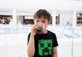 Kid drinking cold soda, Happy Child sitting in cafe drinking soft drink from glass, sitting in cafe drinking soda or soft drink Royalty Free Stock Photo