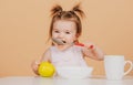 Kid eat healthy nutrition, baby food. Babies eating with spoon. Babys first meal. The child eats on his own with a spoon Royalty Free Stock Photo