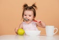 Kid eat healthy nutrition, baby food. Babies eating with spoon. Babys first meal. The child eats on his own with a spoon Royalty Free Stock Photo