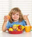 Kid eating apple. Portrait of child eat fresh healthy food in kitchen at home. Kid boy eating breakfast before school. Royalty Free Stock Photo