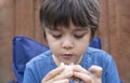 Kid eating burger with mixed vegetables in the garden, Hungry Child boy siting outside eating his homemade picnic food, Spring or