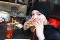 Kid eating burger on restaurant terrace Royalty Free Stock Photo