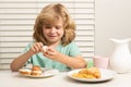 Kid eating egg. Portrait of preteen child eat fresh healthy food in kitchen at home. Kid boy eating breakfast before Royalty Free Stock Photo