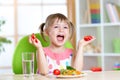 Kid eating healthy vegetables food at home or Royalty Free Stock Photo