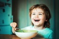 Kid eating. Little boy having breakfast in the kitchen. Smiling happy adorable baby eating fruit mash in the kitchen Royalty Free Stock Photo