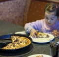 Kid eating pizza in restaurant background