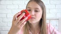 Kid Eating Tomato, Child Eats Fruits, Young Girl Tasting Vegetables at Breakfast in Kitchen, Children Heathcare