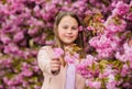 Kid enjoy cherry blossom sakura. Kid on pink flowers sakura tree background. Allergy remedy. Child enjoy life without