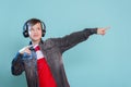 Kid enjoying music on his headphones, listening to music. Handsome young stylish kid in headphones standing against blue backgroun Royalty Free Stock Photo