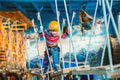 Kid enjoying a summer day and playing. Happy child having fun in adventure park, climbing ropes Royalty Free Stock Photo