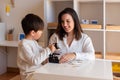 Kid exploring science with a microscope and mother or teacher help. Homeshooling. Learning Community. Montessori School Royalty Free Stock Photo