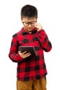 Kid with eyeglasses trying to read  book on tablet Royalty Free Stock Photo
