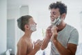 Kid, father and learning to shave, funny or bonding together in home bathroom. Laughing, dad and teaching child with Royalty Free Stock Photo