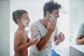 Kid, father and learning to shave, laughing and bonding together in bathroom. Funny, dad and teaching child with shaving Royalty Free Stock Photo