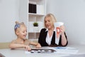 Kid with female speech therapist in the white cabinet.