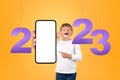 Kid finger pointing at big phone mockup display, 2023 year Royalty Free Stock Photo