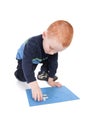 Kid finishing puzzle with last and final piece Royalty Free Stock Photo