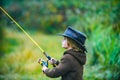 Kid with fishing rod at lake. Little boy catching a fish. Lonely happy little child fishing from beach lake or pond Royalty Free Stock Photo