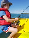 Kid fishing from small dinghy on Tauranga Harbour.